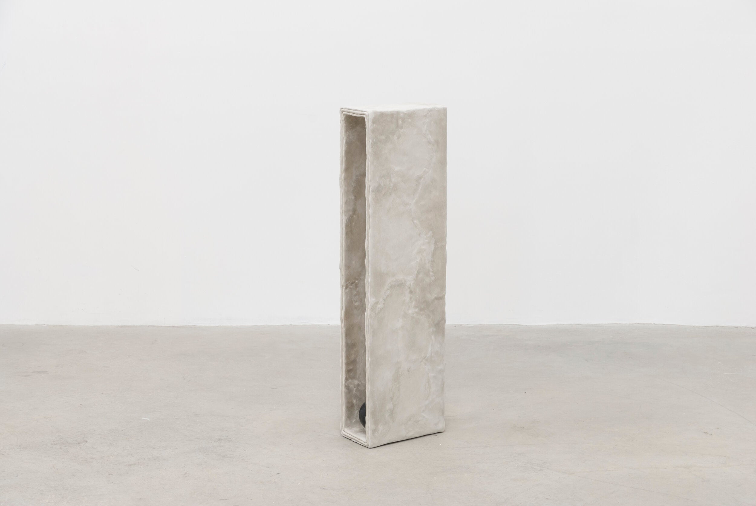 Side view of tall minimalist hand sculpted designer side table by artist Bailey Fontaine. Represented by design gallery Tuleste Factory in New York City.