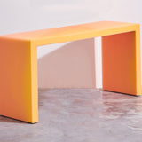 The resin desk features a matte exterior in a warm hue. Represented by Tuleste Factory, a design gallery in Chelsea, New York.