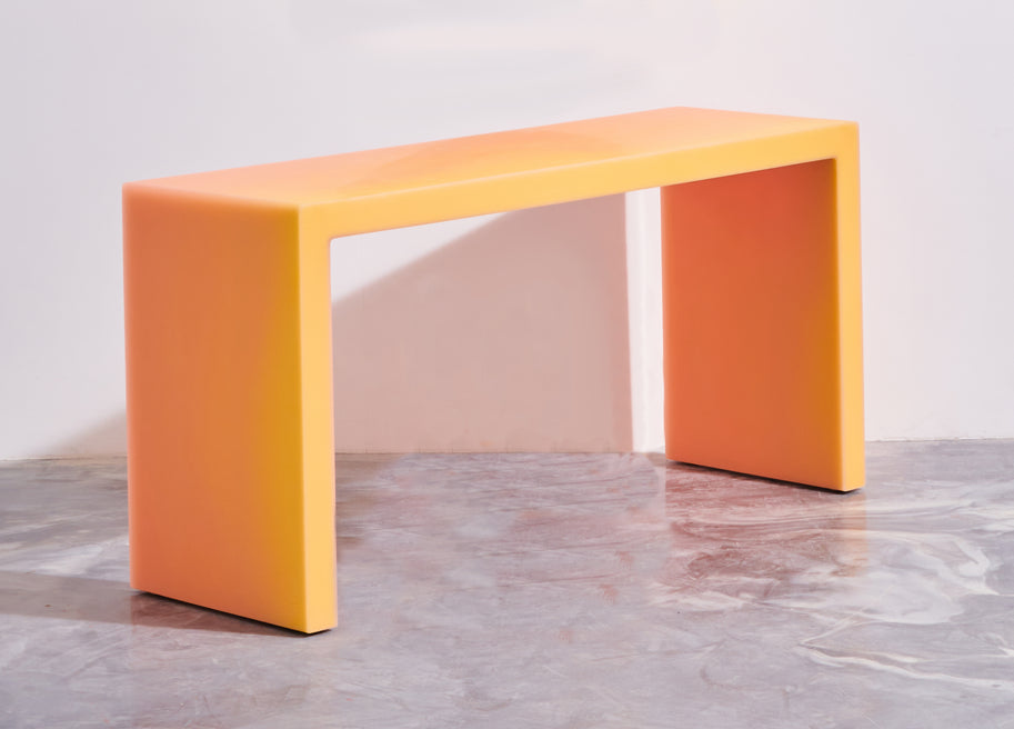 The resin desk features a matte exterior in a warm hue. Represented by Tuleste Factory, a design gallery in Chelsea, New York.